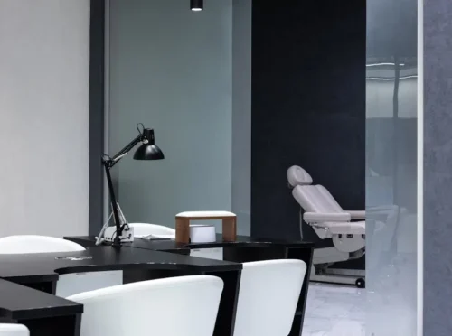 Modern clinic or office space with black and white decor and a reclining chair.